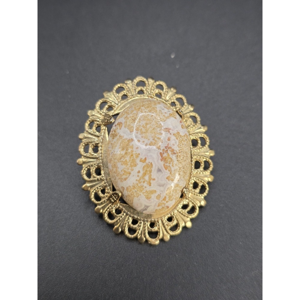gold-toned brooch/pendant featuring a large oval cabochon of Mexican crazy Lace